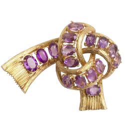 Gouden strikbroche volop bezet met amethisten gemaakt in Italie in de 70er jaren