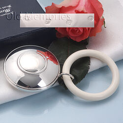 Ronde zilveren rammelaar met parelrand 