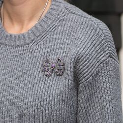 Grote zilveren strikbroche bezet met amethist