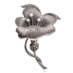 De zilveren bloem broche met zaadpareltjes en markasiet schittert in het zachte licht, een musthave accessoire voor liefhebbers 