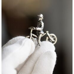 Miniatuur zilveren loopfiets met man of kind, Nederland na 1953