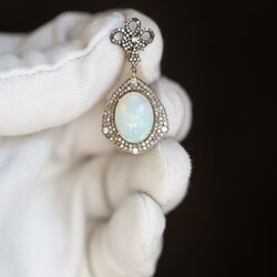 Een sprookje gouden oorbellen gestrikt met een opaal en diamanten